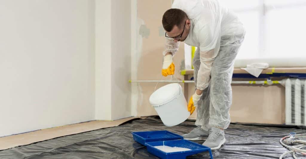 trabajador echando pintura blanca
